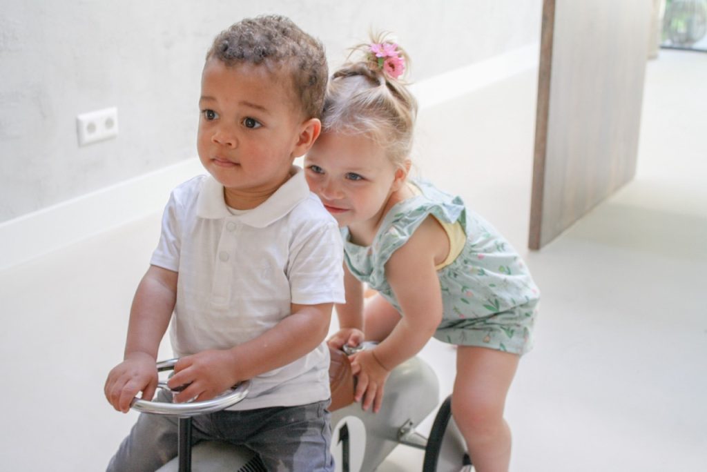 two children playing on a bike