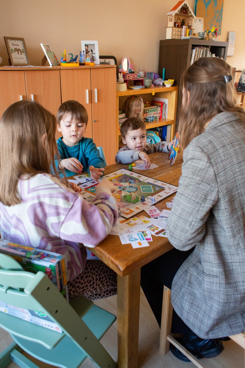 babysitter playing games with the children at the table