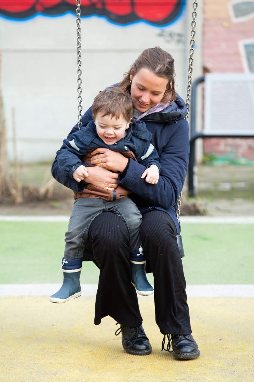 babysitter sitting on a swing with the child