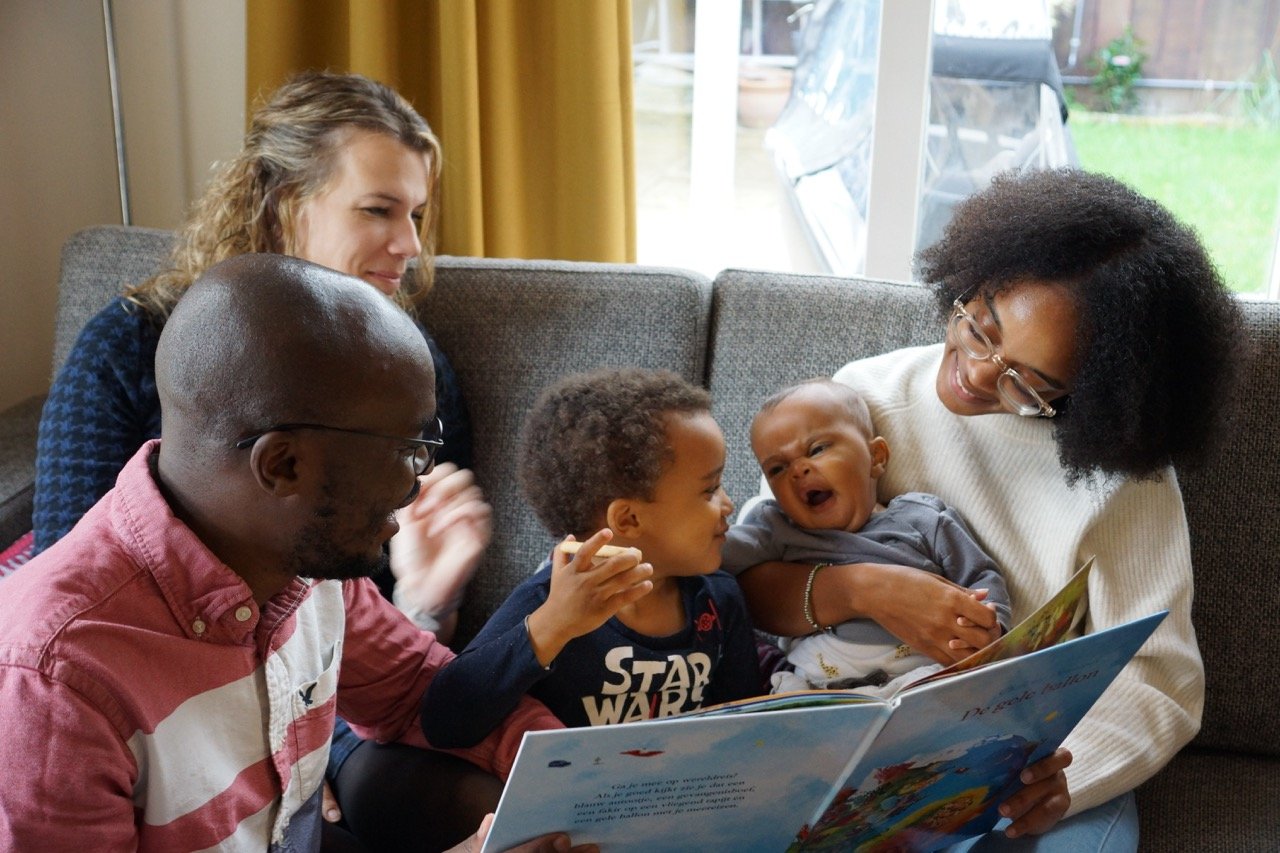 a family laughing while reading a book