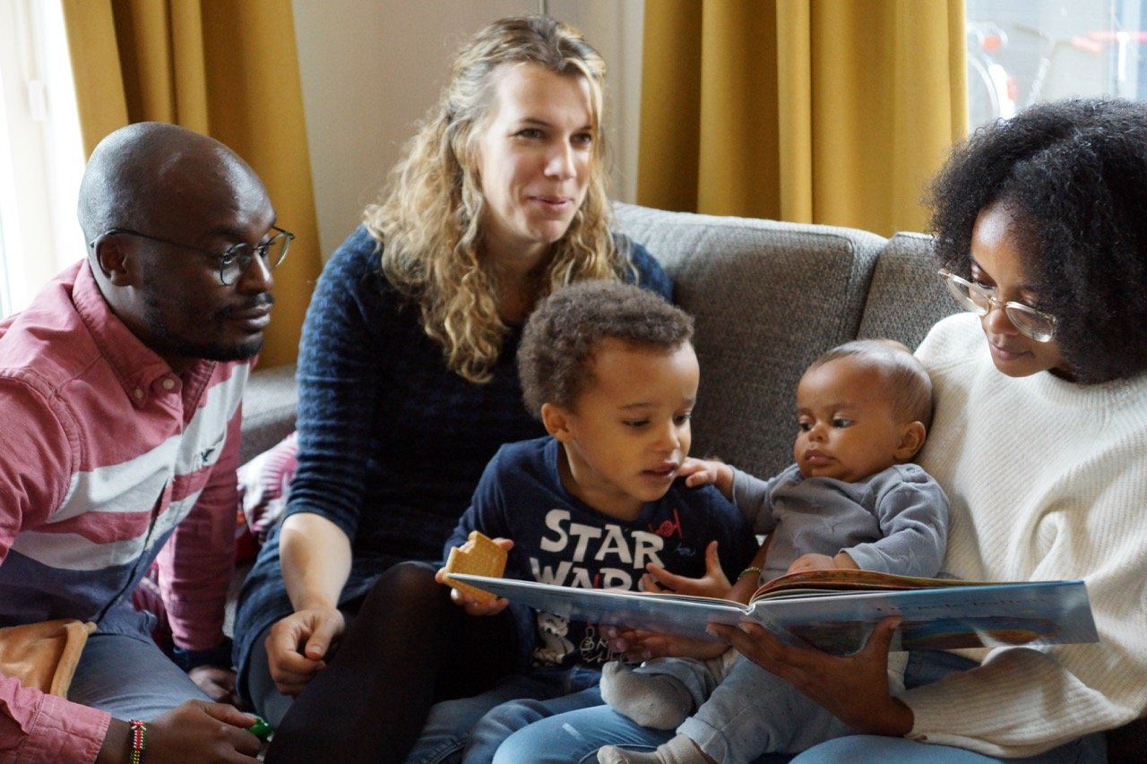 the whole family looking in the book together